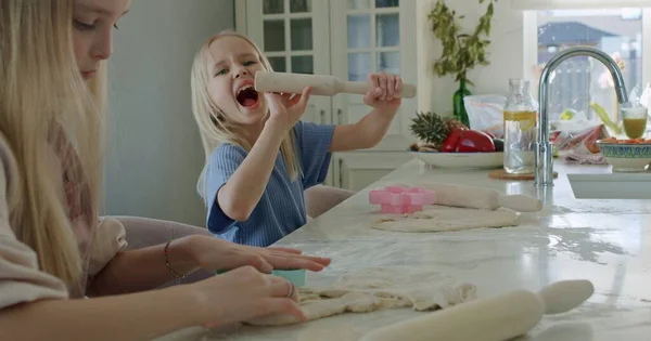 Mädchen rollt Teig auf Küchentisch — Stockfoto