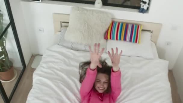 Szczęśliwa kobieta upadająca na łóżko — Wideo stockowe