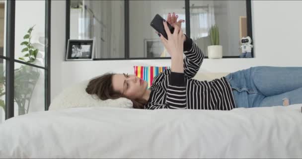 女孩无聊的躺在床上 — 图库视频影像