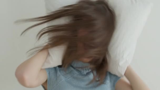 Woman having fun with white pillow — Stock Video