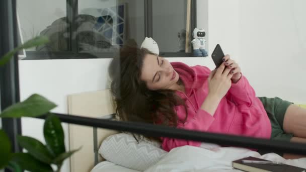 Chica acostada en la cama y muy sorprendida — Vídeos de Stock