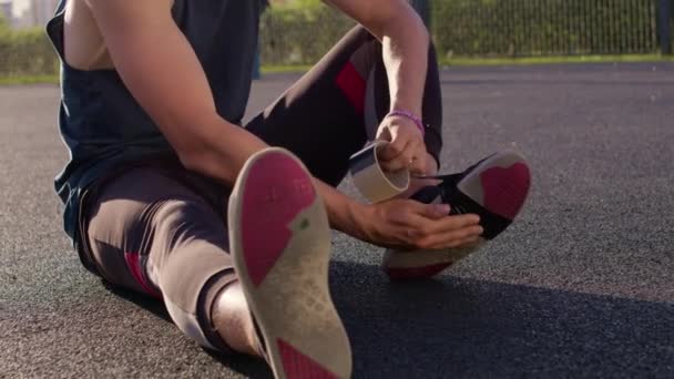 Man taping rond een lekkende sneaker — Stockvideo