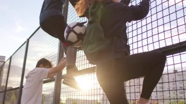 サッカー選手はフェンスを越えて登り — ストック動画