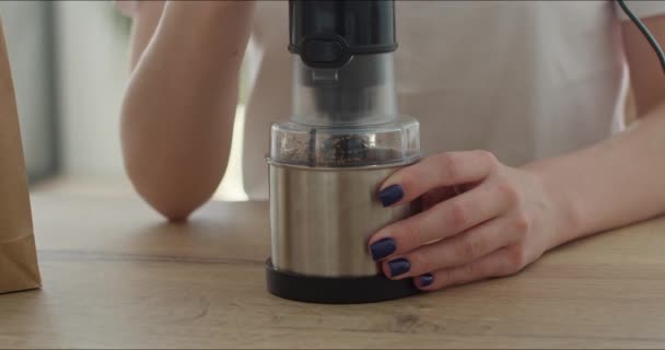 Молодая женщина шлифует кофейные зёрна — стоковое видео