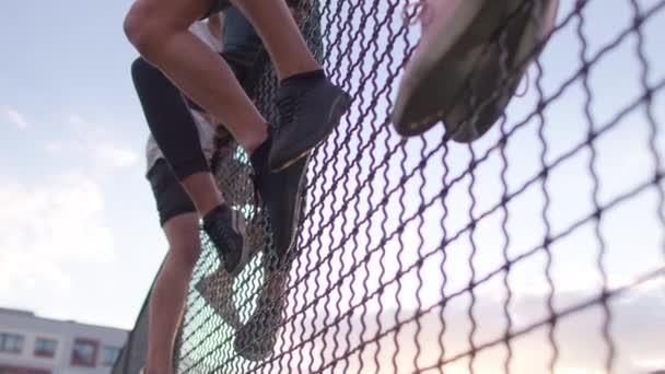 Football player climbs over fence — Stock Video