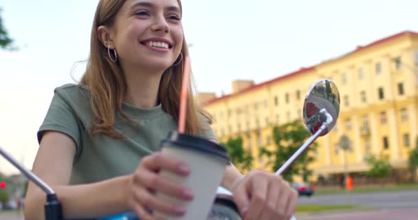 Fille est assise sur le vélo et boit du café — Video