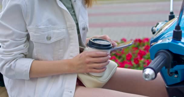 Menina senta-se na bicicleta e bebe café — Vídeo de Stock