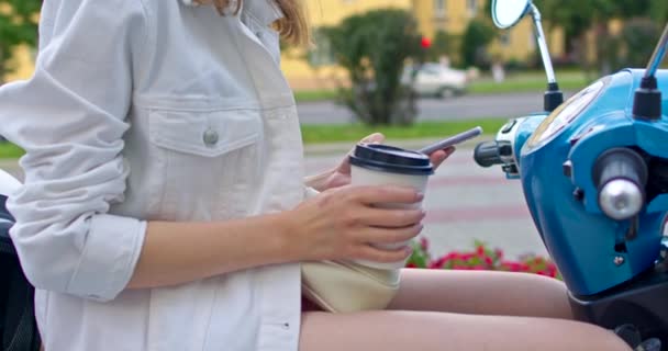 Dziewczyna siedzi na rowerze i pije kawę — Wideo stockowe
