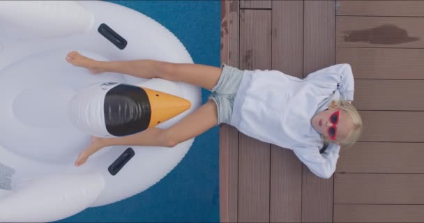 Criança sozinha deitado na borda da piscina — Vídeo de Stock