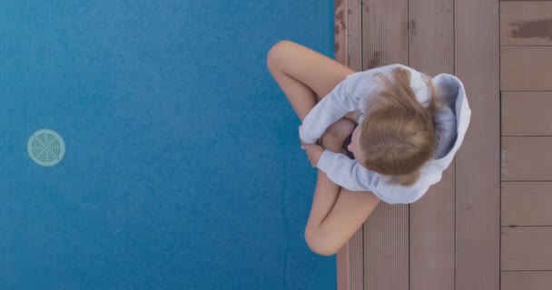 Gyermek egyedül ül a medence szélén — Stock videók