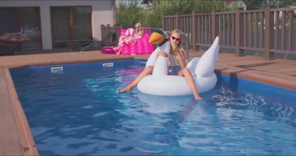 Niño nada en el cisne en la piscina azul — Vídeos de Stock