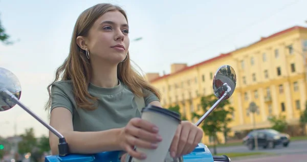 Girl sits on bike and drinks juice — Stock Photo, Image