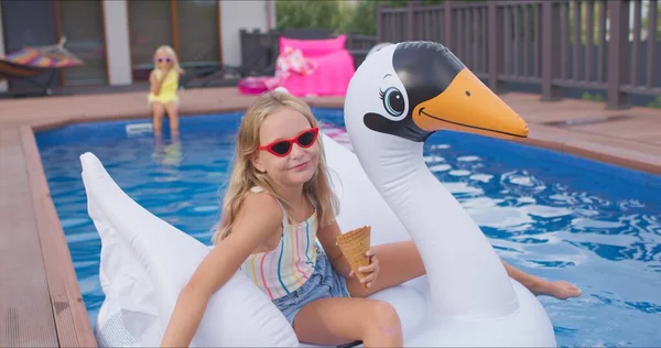 Niño nada en el cisne en la piscina azul —  Fotos de Stock