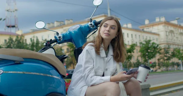 Девушка, сидящая на велосипеде и жующая телефон — стоковое фото