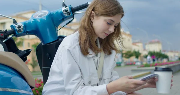 Девушка, сидящая на велосипеде и жующая телефон — стоковое фото