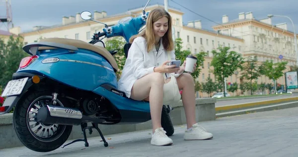 Flicka sitter på cykel och cheking telefon — Stockfoto