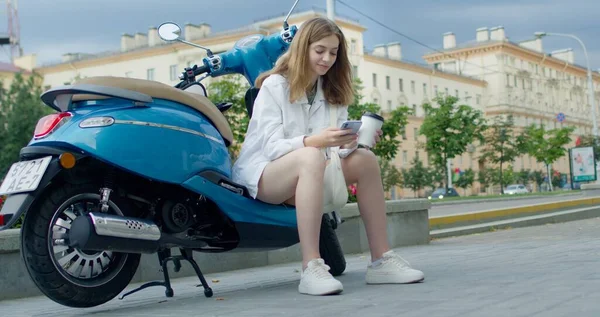 Girl siting on bike and cheking phone — Stock Photo, Image