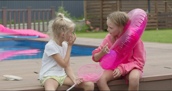 Hermanas sentadas cerca de la piscina — Foto de Stock