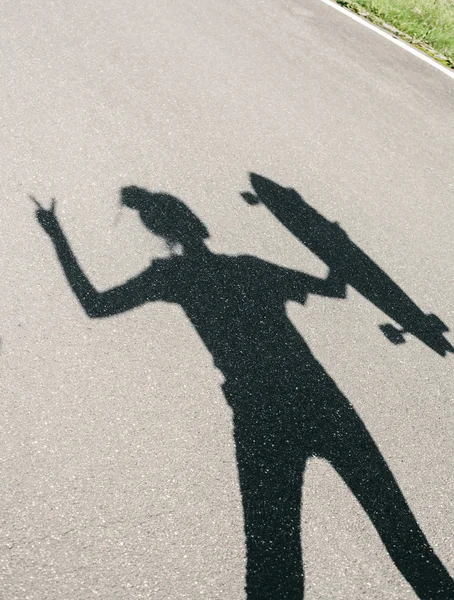 Ombre de jeune femme posant avec skateboard — Photo