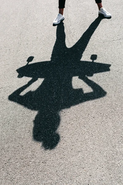 Shadow of young woman posing with skateboard — Stock Photo, Image