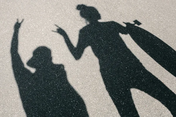 Ombre de jeune homme et femme posant avec skateboard — Photo