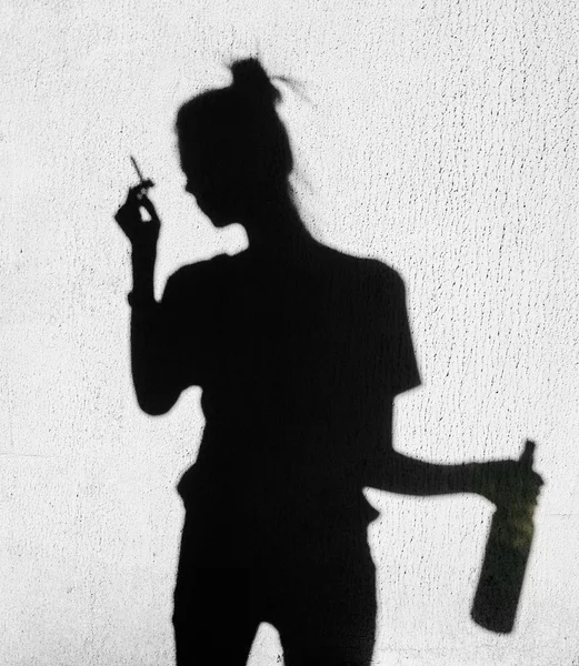 Szomorú lány dohányzás körül a háttérben fal árnyékában — Stock Fotó