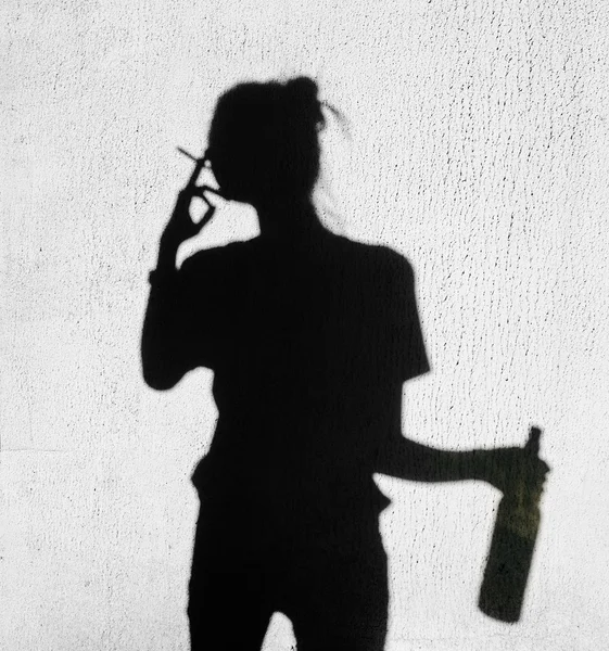 Sombra de mulher fumando ao redor no fundo da parede — Fotografia de Stock