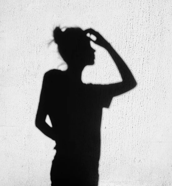 Shadow of girl touching a finger to her head — Stock Photo, Image