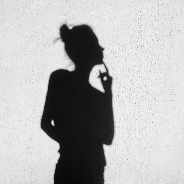 Shadow of girl touching a finger to her lips — Stock Photo, Image