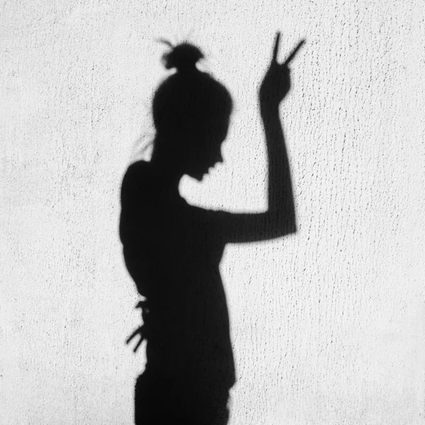 Shadow of girl showing victory by finger — Stock Photo, Image