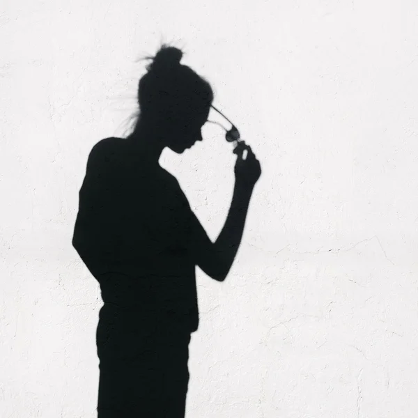 Chica con gafas de sol alrededor sobre fondo de pared — Foto de Stock