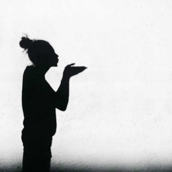 Girl sending an air kiss around on the white wall background — Stock Photo, Image