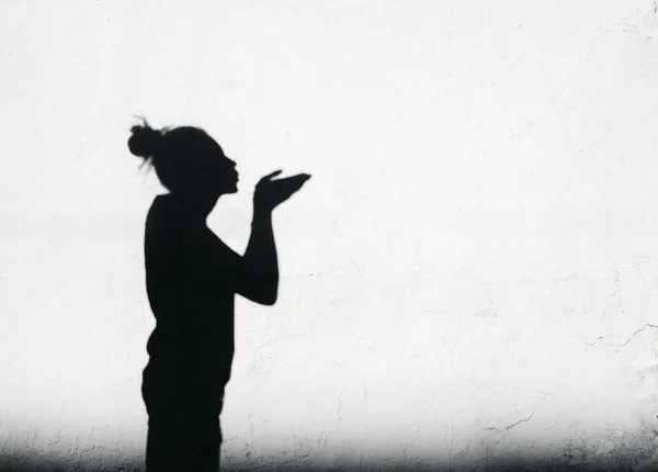 Girl sending an air kiss around on the white wall background — Stock Photo, Image