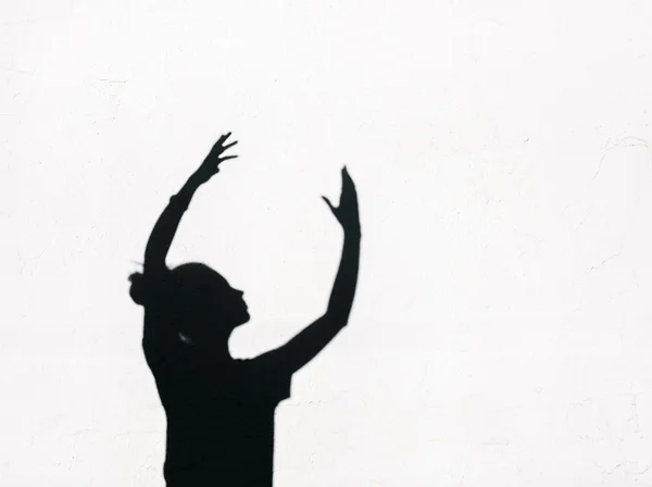 Girl stretching her hands toward the sky around on the white wall background — Stock Photo, Image