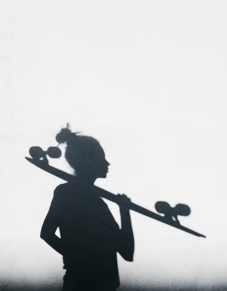 Foto de sombras de menina com um skate — Fotografia de Stock