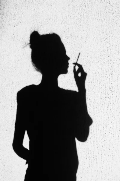 Sombra de chica fumando en el fondo de la pared — Foto de Stock