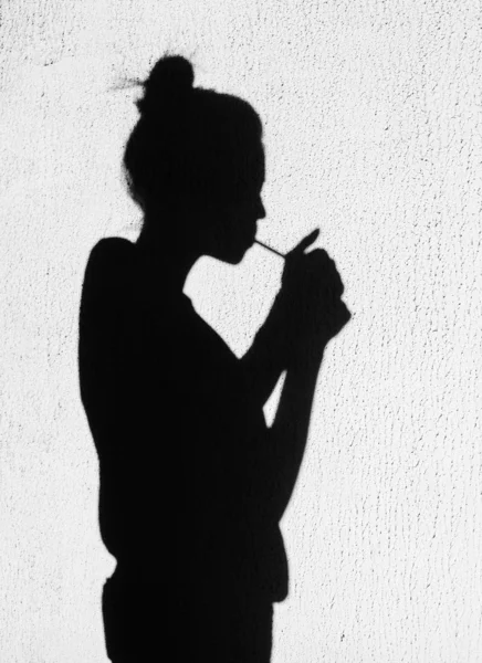 Sombra de mulher fumando ao redor no fundo da parede — Fotografia de Stock
