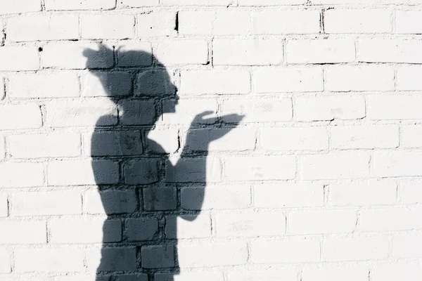 Pretty girl sending an air kiss around on the brick wall background — Stock Photo, Image