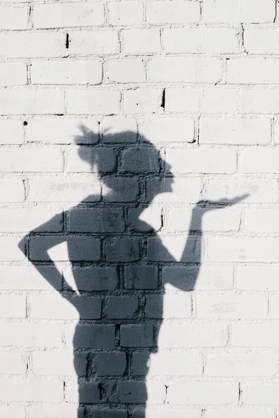 Pretty girl sending an air kiss around on the brick wall background — Stock Photo, Image