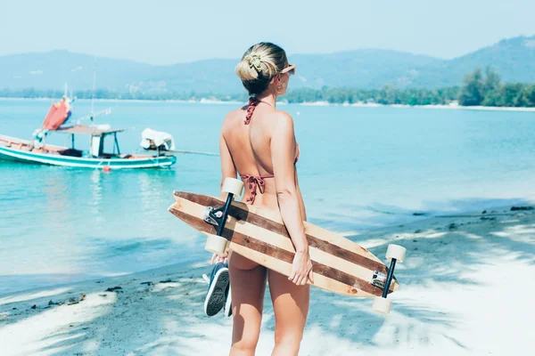 Elinde beyaz kum üzerinde yürüme longboard olan kadın — Stok fotoğraf