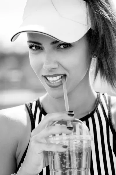 Sporty woman drinking water against the sky — Stock Photo, Image