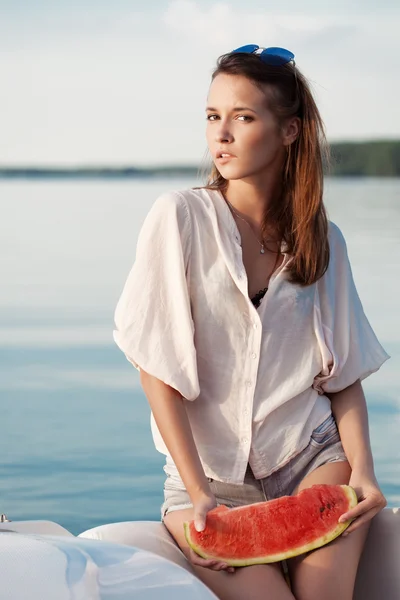 Portret van een mooie vrouw met watermeloen op de zee — Stockfoto