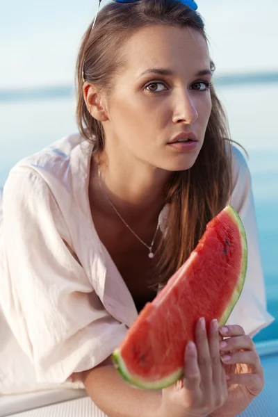 Porträtt av en vacker kvinna med vattenmelon på havet — Stockfoto