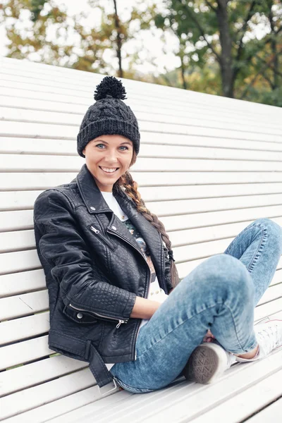 Bir bankta oturan güzel genç kadın — Stok fotoğraf