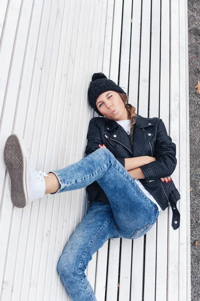 Beautiful young female lying on the bench park — Stock Photo, Image