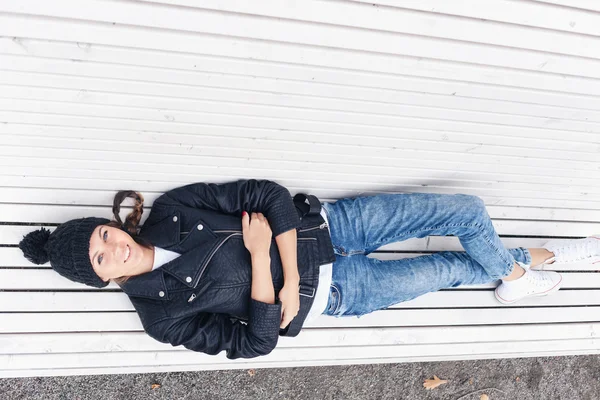 Mooie jonge vrouwelijke liggend op een bankje — Stockfoto