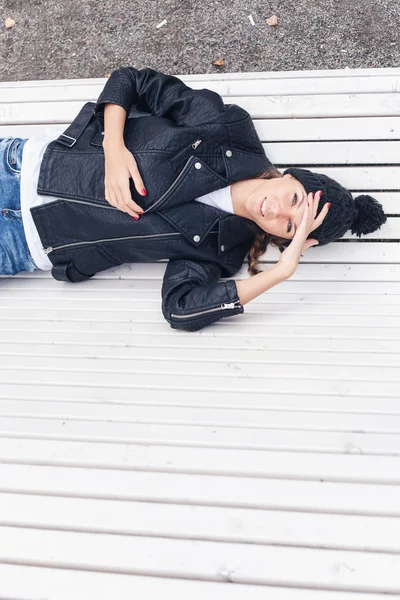 Belle jeune femme allongée sur un banc de parc — Photo