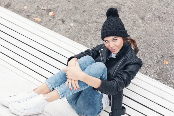 Schöne junge Frau sitzt auf einer Parkbank — Stockfoto