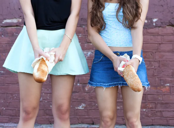 Two young women having fun with bread — Zdjęcie stockowe