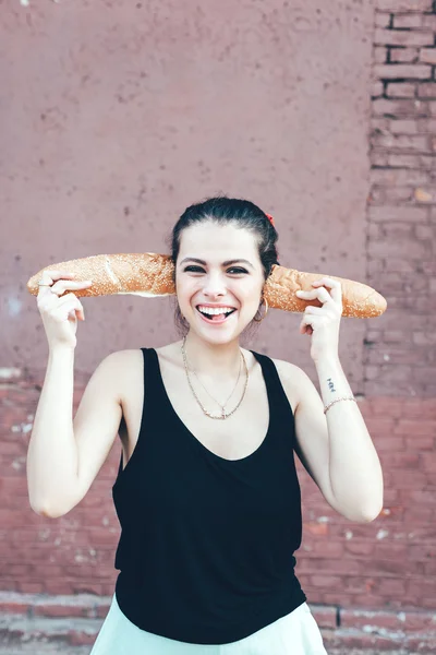 Girl fooling around bread — Stock Fotó